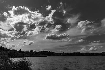 Scenic view of river against cloudy sky