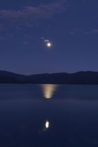 Scenic view of lake against sky at night