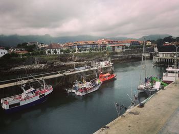 High angle view of boats moored at harbor against sky