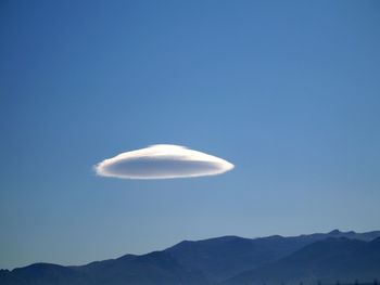 Low angle view of half moon against clear blue sky