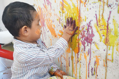 Cute boy painting wall 