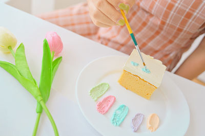 Close-up of hand holding ice cream served in plate