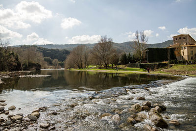 Scenic view of river by trees against sky