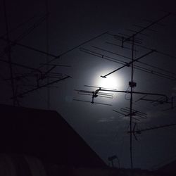 Low angle view of silhouette birds on electricity pylon against sky