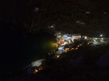 High angle view of illuminated street amidst buildings at night