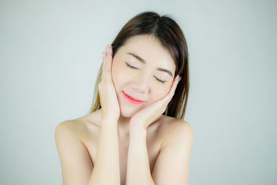 Portrait of a smiling young woman over white background