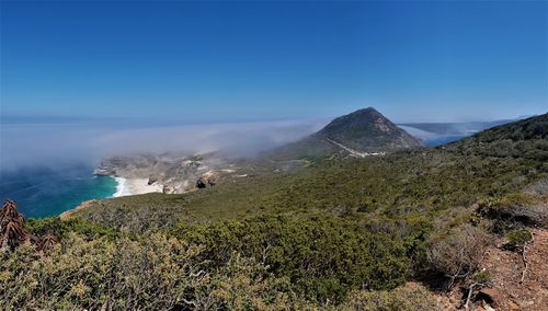 Scenic view of sea and mountains against blue sky