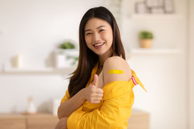 Portrait of a smiling young woman standing at home