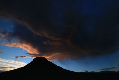 Low angle view of silhouette mountain against dramatic sky
