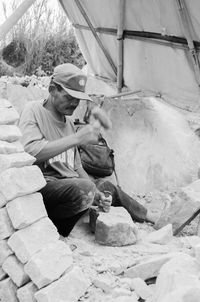 Mason chiseling stone at workshop