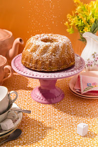 Powdered sugar pouring on freshly made bundt cake