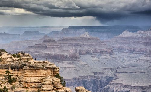 Rock formations on landscape against cloudy sky