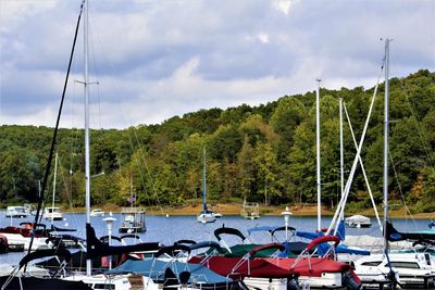 Sailboats moored on river against sky