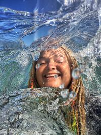 Portrait of smiling young woman swimming in water