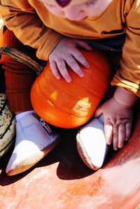 High angle view of hand holding pumpkin