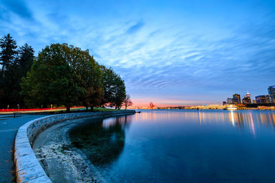 Scenic view of lake against blue sky at dusk