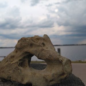 Close-up of rock on beach against sky