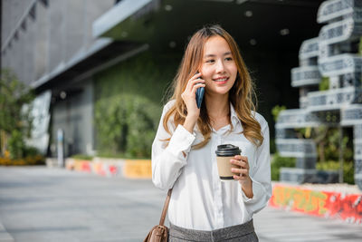 Young woman using mobile phone in city