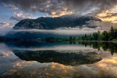 Scenic view of lake and mountains against sky during sunset