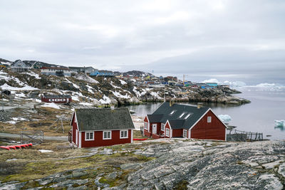 Houses by sea against sky