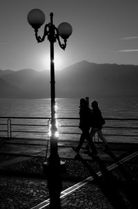 Couple walking on pier over sea