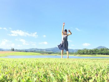 Woman standing on field against sky