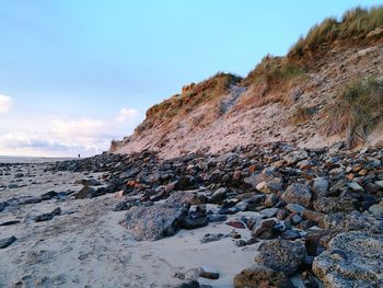 Scenic view of rocks at beach against sky