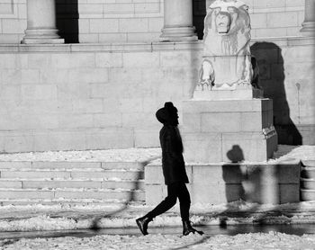 Rear view of man walking on wall