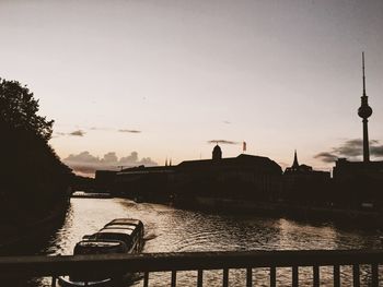 River by city against sky during sunset