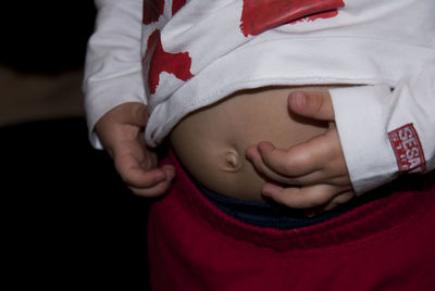 Midsection of child touching stomach