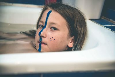 Close-up of girl with face paint in bathroom