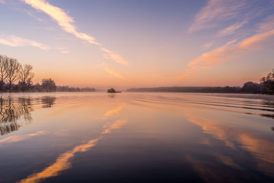 Scenic view of lake against sky at sunset