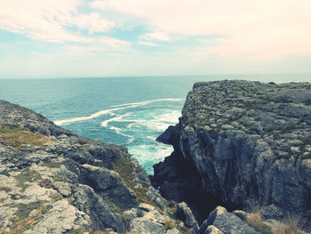 Rock formations by sea against sky