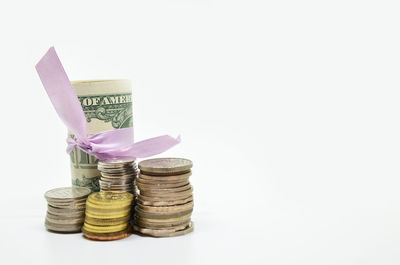 Close-up of coins in container against white background