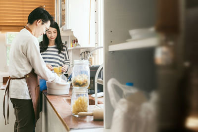 Man with woman preparing pasta in kitchen at home