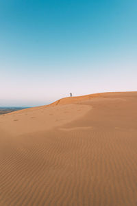 Scenic view of desert against clear blue sky