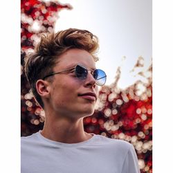 Young man wearing sunglasses looking away in park