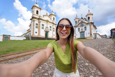 Holidays in minas gerais, brazil.  girl takes selfie picture with smartphone in mariana, brazil.