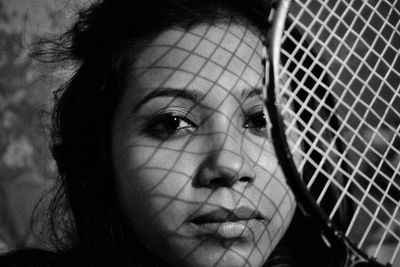 Close-up portrait of woman with tennis racket