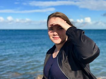 Portrait of woman against sea in sunny day