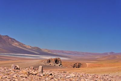 Scenic view of desert against clear blue sky