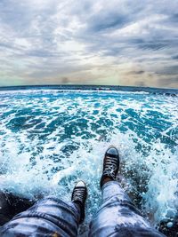 Low section of person splashing water in sea