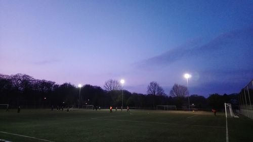 People on soccer field against sky