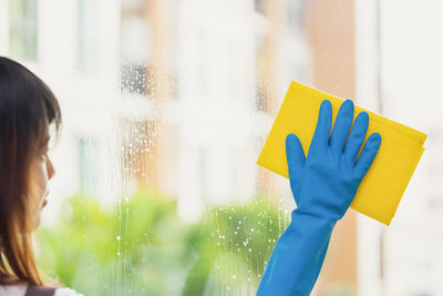 Woman wiping wet glass window