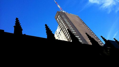 Low angle view of silhouette built structure against clear blue sky