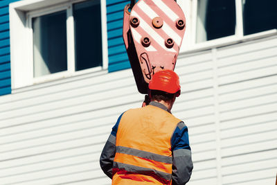 Rear view of woman standing against wall