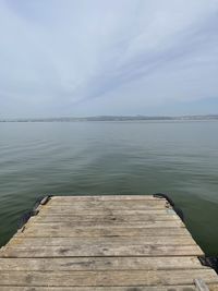 Pier over lake against sky