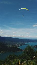 Paragliding over annecy lake against blue sky on sunny day