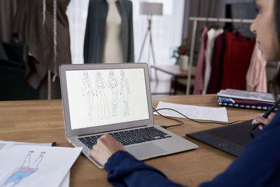 Midsection of businesswoman using laptop at office
