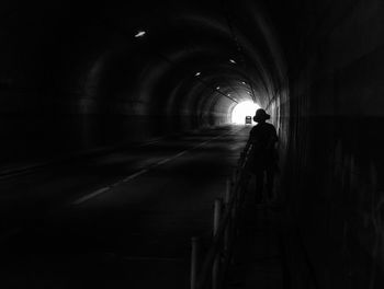 Rear view of silhouette man walking in tunnel